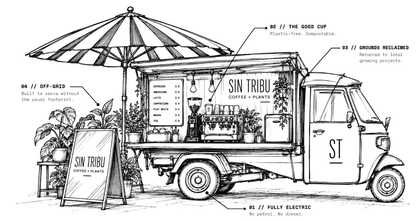 The Sin Tribu van: a three-wheeled coffee van with its side open under a canopy, an espresso machine, grinder and cups on the counter, a chalked menu board, a parasol and an A-board on the pavement.